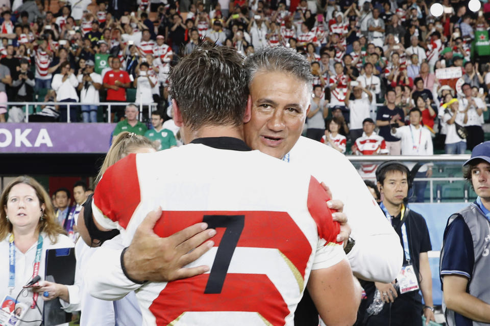 Japan's head coach Jamie Joseph, right, hugs captain Pieter Labuschagne after winning over Ireland during the Rugby World Cup Pool A game at Shizuoka Stadium Ecopa between Japan and Ireland in Shizuoka, Japan, Saturday, Sept. 28, 2019. (Kyodo News via AP)