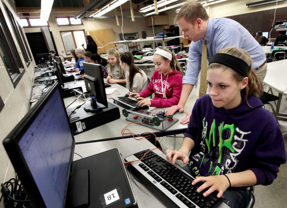 Students learn to program robots by computer in a pre-engineering class.