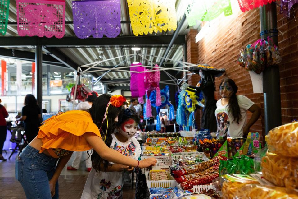 People browse the booths at the annual Dia de los Muertes celebration hosted by Una Mano Amiga at Trolley Square in Salt Lake City on Saturday.