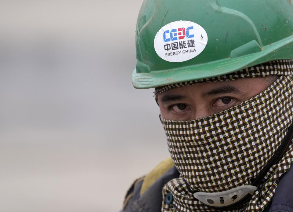 A Vietnamese worker rides a bicycle on his way to start his working day at the first Chinese car tire factory in Europe near the northern Serbian town of Zrenjanin, 50 kilometers north of Belgrade, Serbia, Thursday, Nov. 18, 2021. Reports have emerged in Serbia of prison-like conditions for some 500 of them at the construction site in north of the country where China's Shandong Linglong Tire Co is building the huge factory. Populist-run Serbia is a key spot for China's expansion and investment policies in Europe and Chinese companies have kept a tight lid on their projects in the country amid reports of disrespect of the Balkan nation's anti-pollution laws and labor regulations. (AP Photo/Darko Vojinovic)