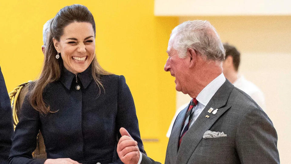 Kate Middleton laughing as King Charles talks to her.