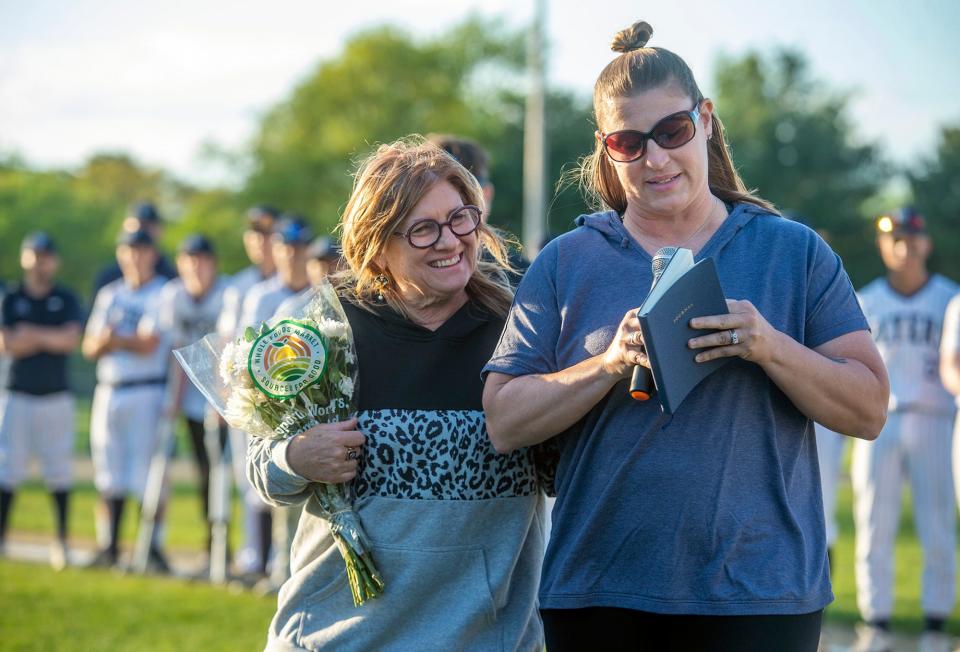 Amanda Smith, daughter of Paul "Bunkie" Smith, with her mother, Cheryl, speaks before the Paul "Bunkie" Smith Memorial game between Framingham High School and Natick High School, May 13, 2024. Smith, a former coach and player, died Sept. 24, 2023.