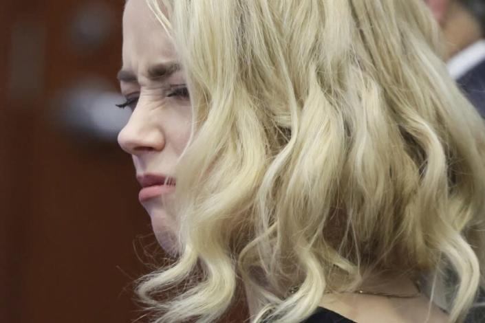 Actor Amber Heard looks at her attorney before the verdict was read at the Fairfax County Circuit Courthouse in Fairfax, Va, Wednesday, June 1, 2022. The jury awarded Johnny Depp more than $10 million in his libel lawsuit against ex-wife Amber Heard. It vindicates his stance that Heard fabricated claims that she was abused by Depp before and during their brief marriage. But the jury also found in favor of Heard, who said she was defamed by a lawyer for Depp.(Evelyn Hockstein/Pool via AP)