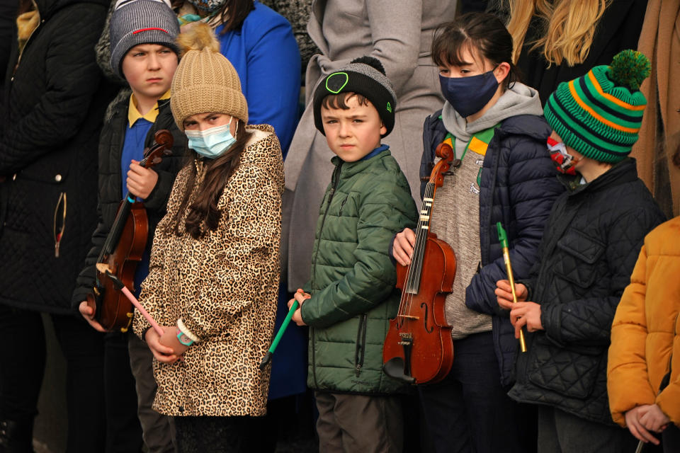 Young musicians form a guard of honour outside St Brigid's Church, Mountbolus, Co Offaly, for the funeral of Ashling Murphy, who was murdered in Tullamore, Co Offaly last Wedensday. 23-year-old Ashling, a primary school teacher and a talented musician, was found dead after going for a run on the banks of the Grand Canal in Tullamore.. Picture date: Tuesday January 18, 2022.