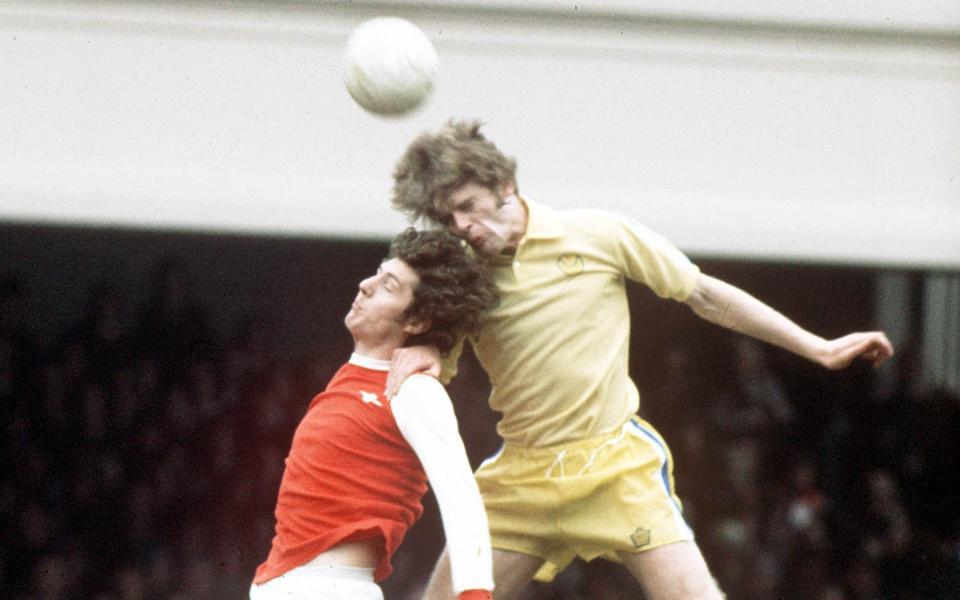 Gordon McQueen salta por el balón con Brian Kidd durante un partido entre Arsenal y Leeds en 1975