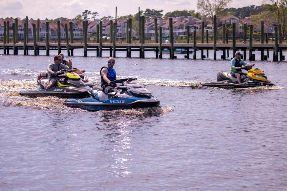 Jet ski riders pass the docks of Little River on the Intracoastal Waterway on Friday. April 17, 2020