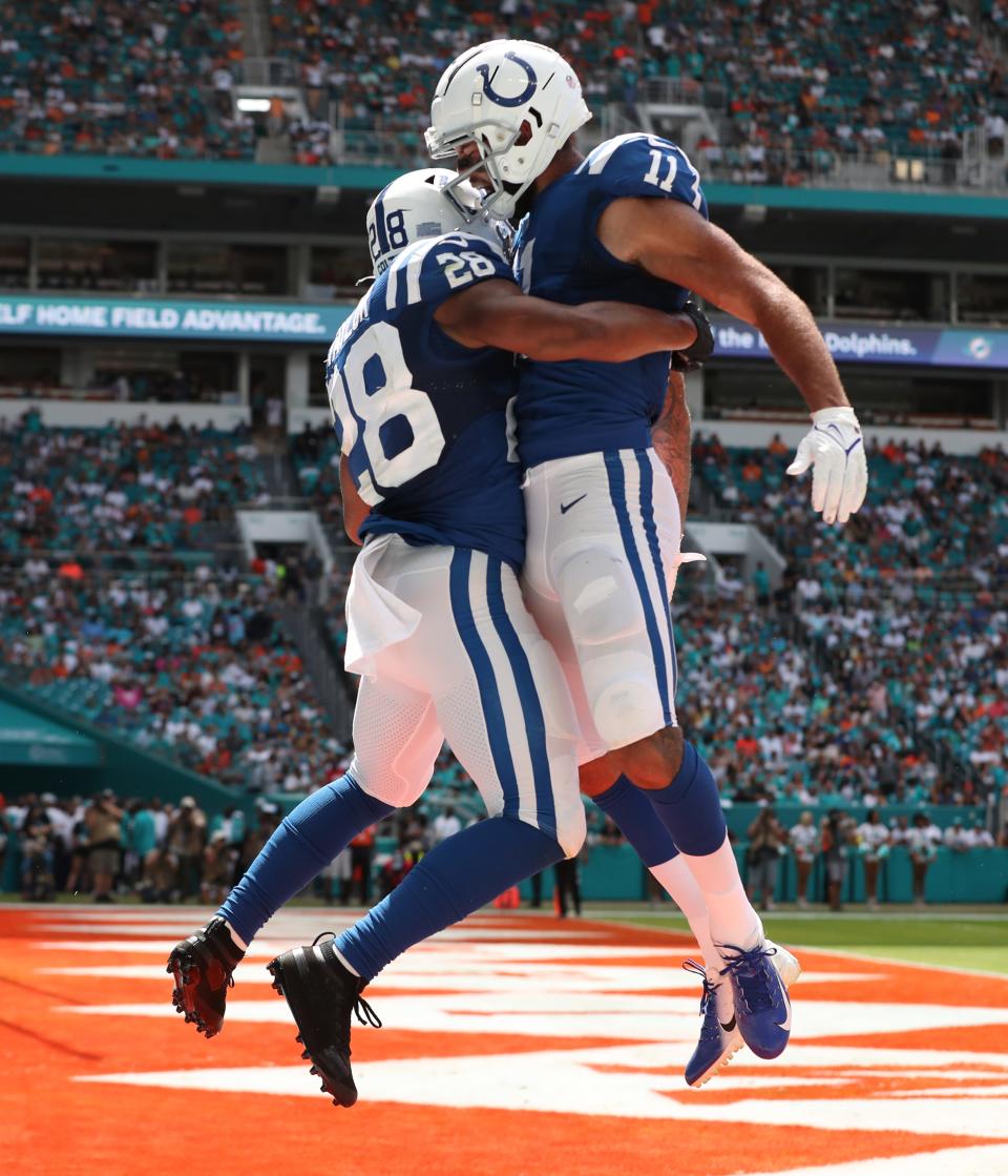 Jonathan Taylor (left), jumps with teammate Michael Pittman Jr. after Taylor’s Colts touchdown at Hard Rock Stadium in Miami Gardens, Fla., on Sunday, Oct. 3, 2021, during first half Miami vs. Indianapolis action. 