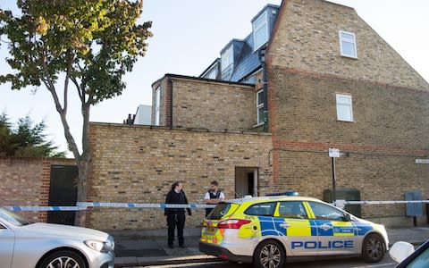 Police pictured on Friday morning outside the property where the body was found in Southfields - Credit: Paul Grover for The Telegraph