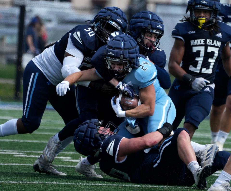 URI's Matthew Osinaga (50), Emmanuel Gomes (27) and Cole Brockwell (39) bring down running back Rocco Cillino during first-half action in their spring Blue-White game.