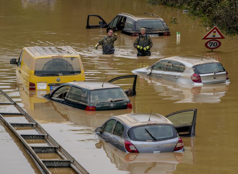 Los ayudantes buscan víctimas en automóviles inundados en una carretera en Erftstadt, Alemania.
