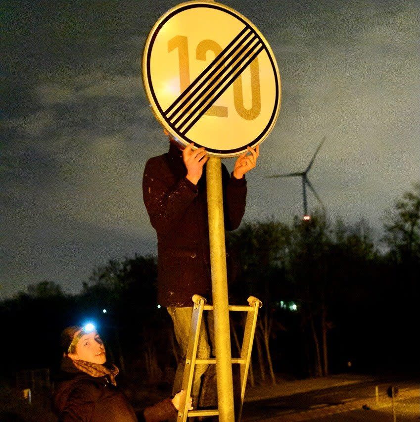 Activists take down a no limit sign using a step ladder