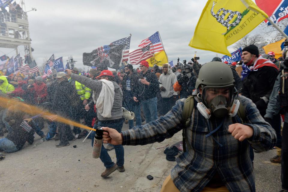 A rioter wearing a gas mask and helmet clashes with security forces at the Capitol, January 06, 2021.
