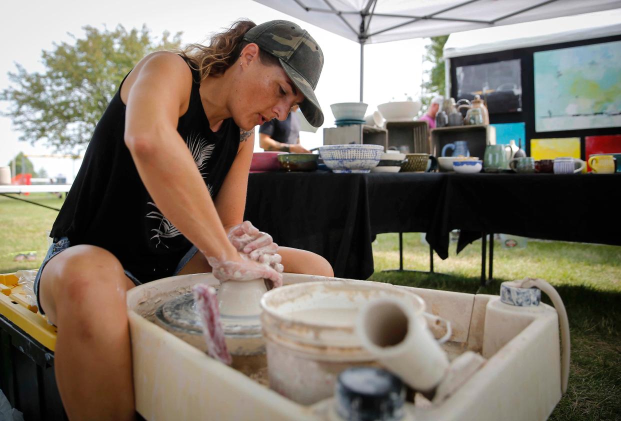 Melissa Reisinger, a clay sculptor from Indianola, shapes a ball of clay into a soup bowl at her booth during the Waukee Art Festival on Saturday, July 17, 2021, at Centennial Park in Waukee.