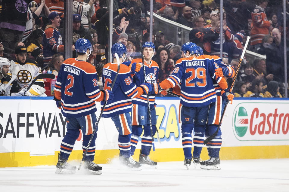 Edmonton Oilers' Evan Bouchard (2), Philip Broberg (86), Connor McDavid (97), Leon Draisaitl (29) and Zach Hyman (18) celebrate after a goal against the Boston Bruins during first-period NHL hockey game action in Edmonton, Alberta, Monday, Feb. 27, 2023. (Jason Franson/The Canadian Press via AP)