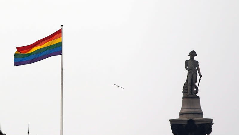 The rainbow flag flies over a building next to Nelson's Column monument, right, in Trafalgar Square, central London, Britain, Friday, March 28, 2014.