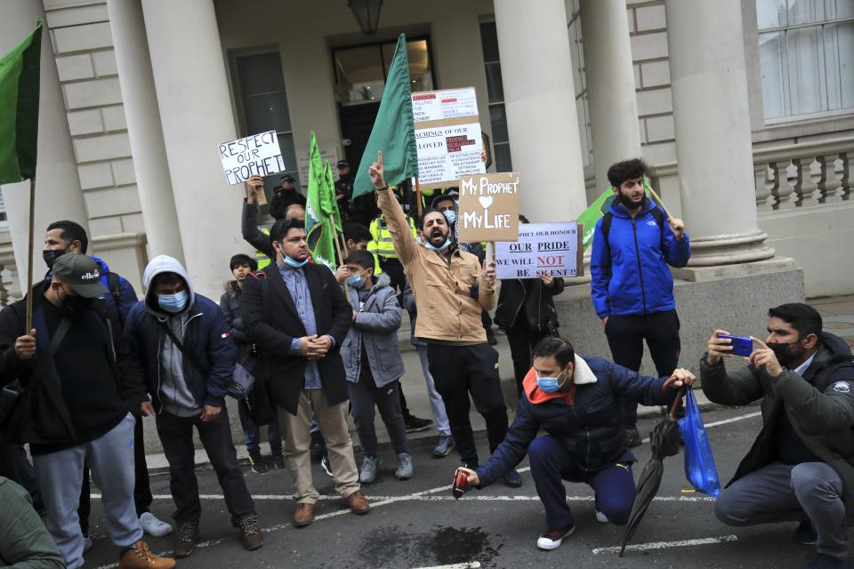 <p>Demonstrators pour perfume onto the street outside the French Embassy in London</p>PA