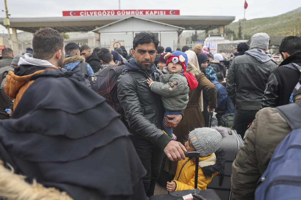 Syrians wait to cross into Syria from Turkey at the Cilvegozu border gate, near the town of Antakya, southeastern Turkey, Tuesday, Feb. 21, 2023. The death toll in Turkey and Syria rose to eight in a new and powerful earthquake that struck two weeks after a devastating temblor killed nearly 45,000 people, authorities and media said Tuesday. (AP Photo/Unal Cam)