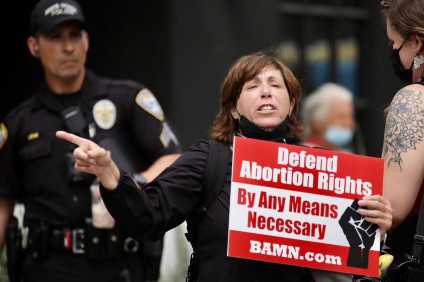 A Santa Monica police officer stands up as River Huston (cq) protest at the Planned Parenthood location on Promenade in Santa Monica.