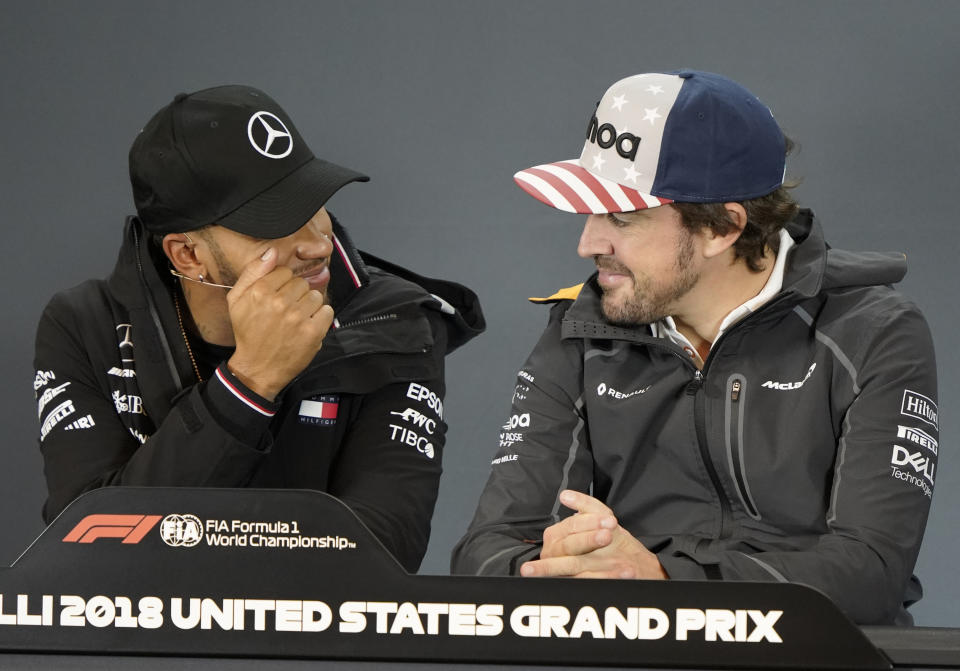 Mercedes driver Lewis Hamilton, left, of Britain, talks with McLaren driver Fernando Alonso, of Spain, during a news conference for the Formula One U.S. Grand Prix auto race at the Circuit of the Americas, Thursday, Oct. 18, 2018, in Austin, Texas. (AP Photo/Darren Abate)