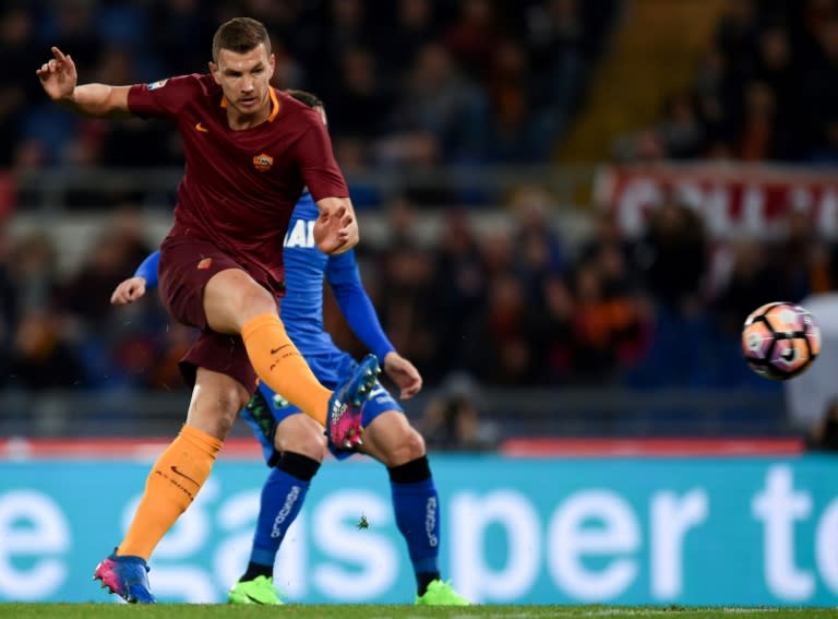 Roma's forward Edin Dzeko (L) shoots and scores against Sassuolo at the Olympic Stadium in Rome on March 19, 2017