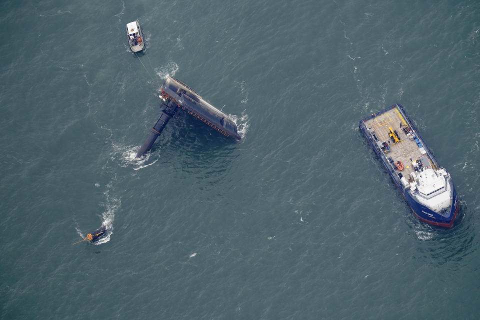 FILE - Rescue boats are seen next to the capsized lift boat Seacor Power seven miles off the coast of Louisiana in the Gulf of Mexico, April 18, 2021. An outage involving a Coast Guard marine warning system and “data gaps” in existing radar systems were contributing factors in last year’s deadly capsizing of an oil industry offshore “lift boat” off of Louisiana’s coast, the National Transportation Safety Board said in a report issued Tuesday, Oct. 18, 2022. (AP Photo/Gerald Herbert, File)