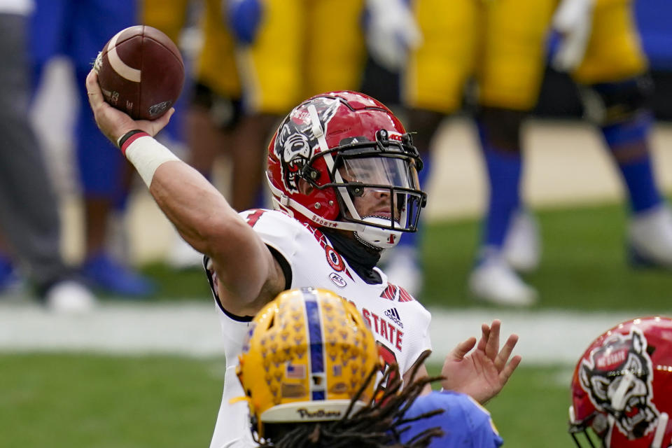 North Carolina State quarterback Devin Leary (13) gets a pass away as Pittsburgh Panthers defensive lineman Patrick Jones II (91) pressures in the first half of an NCAA college football game, Saturday, Oct. 3, 2020, in Pittsburgh. (AP Photo/Keith Srakocic)