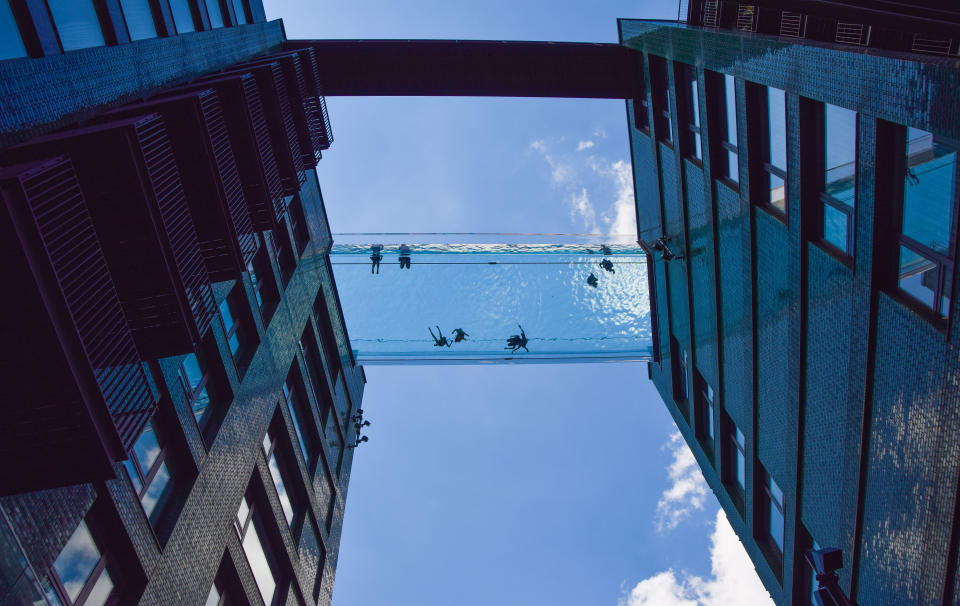 LONDON, UNITED KINGDOM - 2021/06/05: People are seen swimming in a newly opened Sky Pool in London. 
A completely transparent swimming pool suspended 35 meters above ground between two apartment buildings next to the US Embassy in Nine Elms, the Sky Pool is believed to be the world's first swimming pool of its kind and is open to residents only. (Photo by Vuk Valcic/SOPA Images/LightRocket via Getty Images)