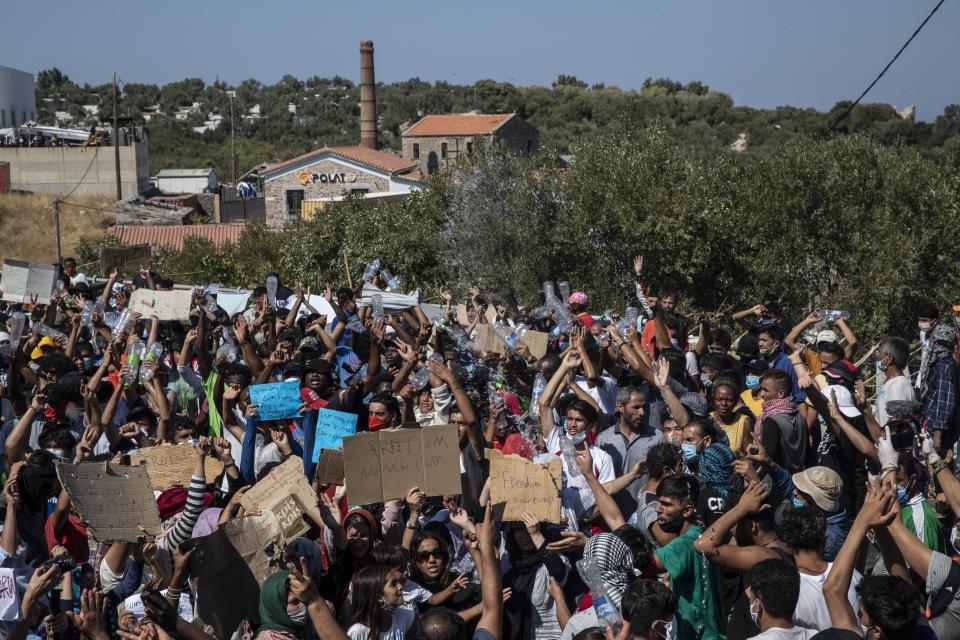 Migrants take part in a rally near Mytilene town, on the northeastern island of Lesbos, Greece, Friday, Sept. 11, 2020. Thousands of protesting refugees and migrants left homeless on the Greek island of Lesbos after fires destroyed the notoriously overcrowded Moria camp have gathered on a road leading to the island's main town, demanding to be allowed to leave. (AP Photo/Petros Giannakouris)