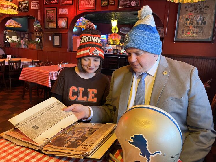 Toledo mayor Wade Kapszukliewicz and wife Sarah look at a scrapbook in a city establishment.