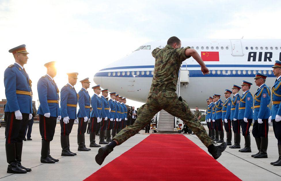 A serviceman jumps over the red carpet as honour guards prepare for the departure of the Chinese President Xi Jinping in Belgrade, Serbia