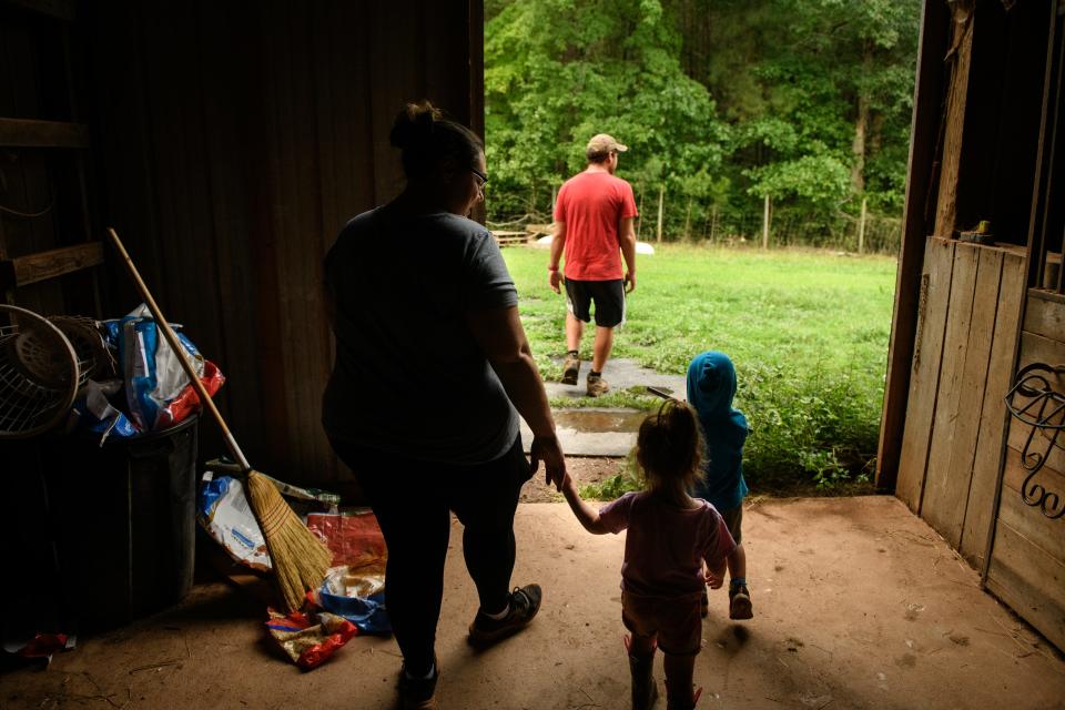 David and Alexandria Rye walk around their farm with their twins, Reagan and Linkoln, at the Rye Family Farm in Sanford. The Rye family bought an abandoned horse farm where they grow mushrooms, raise goats, bake sourdough and grow micro-greens. 