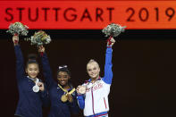 Simone Biles of the United States, center and gold medal, Sunisa Lee of the United States, left and silver medal, and Angelina Melnikova of Russia, right and bronze medal, celebrate during the award ceremony for the floor exercise in the women's apparatus finals at the Gymnastics World Championships in Stuttgart, Germany, Sunday, Oct. 13, 2019. (AP Photo/Matthias Schrader)