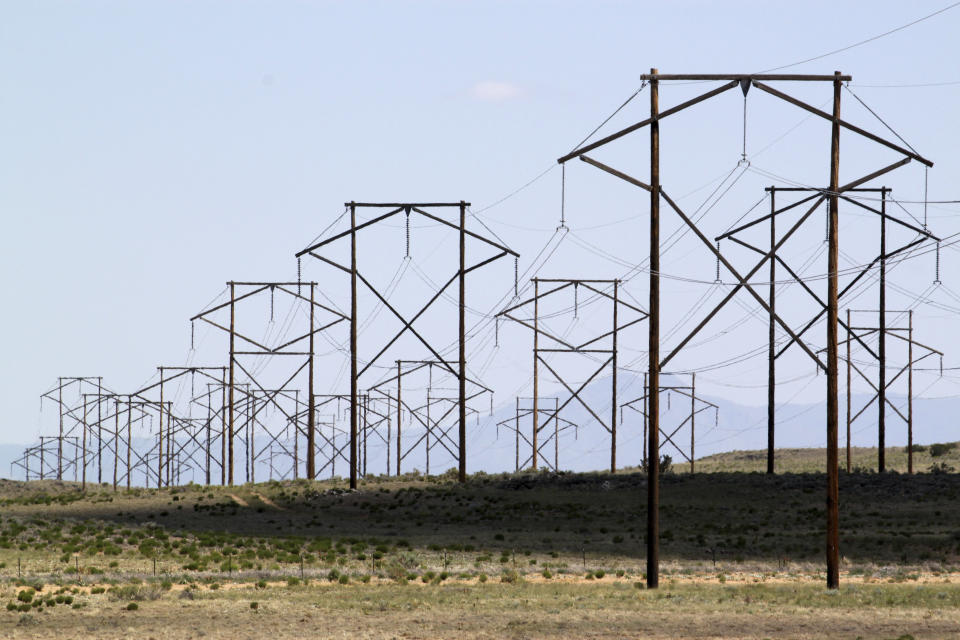 FILE - This May 20, 2012, file photo, shows one of the major transmission lines that runs to the west of Albuquerque, N.M. The parent company of New Mexico’s largest electric utility will become part of energy giant Iberdrola’s global holdings under a multibillion-dollar merger. Under the agreement announced Wednesday, Oct. 21, 2020, Iberdrola's majority-owned U.S. subsidiary Avangrid will acquire PNM Resources and its assets in New Mexico and Texas. The merger will require approval from a number of state and federal regulators in a process that's expected to take the next 12 months. (AP Photo/Susan Montoya Bryan, File)