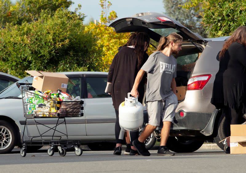 FILE PHOTO: People take out products from their supermarket shopping cart and load them into their car outside Pak'nSave supermarket amid the spread of the coronavirus disease (COVID-19) in Christchurch