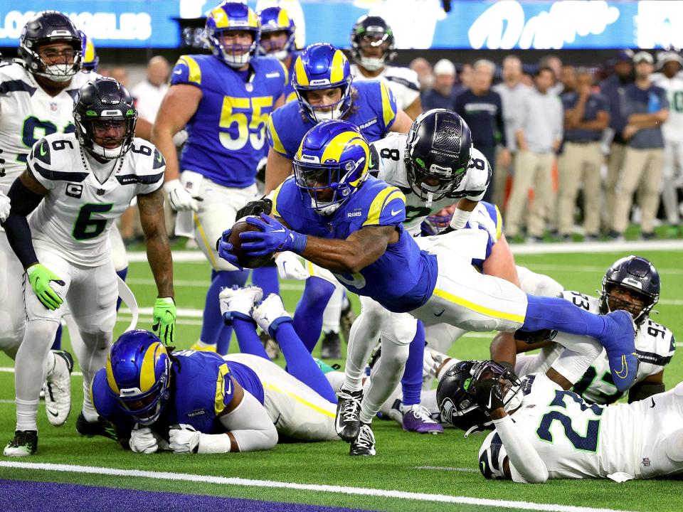 Cam Akers #3 of the Los Angeles Rams dives over Tariq Woolen #27 of the Seattle Seahawks to score a touchdown