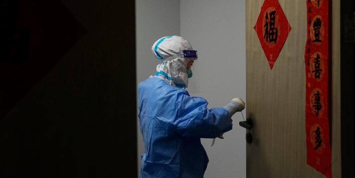 Un trabajador médico toma una muestra de la perilla de una puerta de una oficina para realizar una prueba de COVID-19 en el principal centro de medios en los Juegos Olímpicos de Invierno de 2022, el viernes 2 de febrero de 2020.  11 de febrero de 2022, en Pekín.