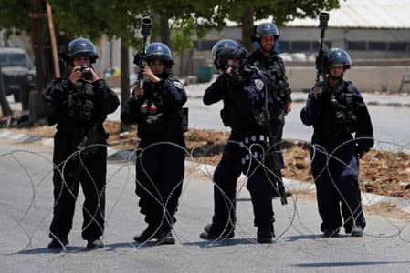 Israeli police members take up position during clashes with Palestinians at a protest against Bahrain's workshop for U.S. peace plan, near Hebron, in the Israeli-occupied West Bank