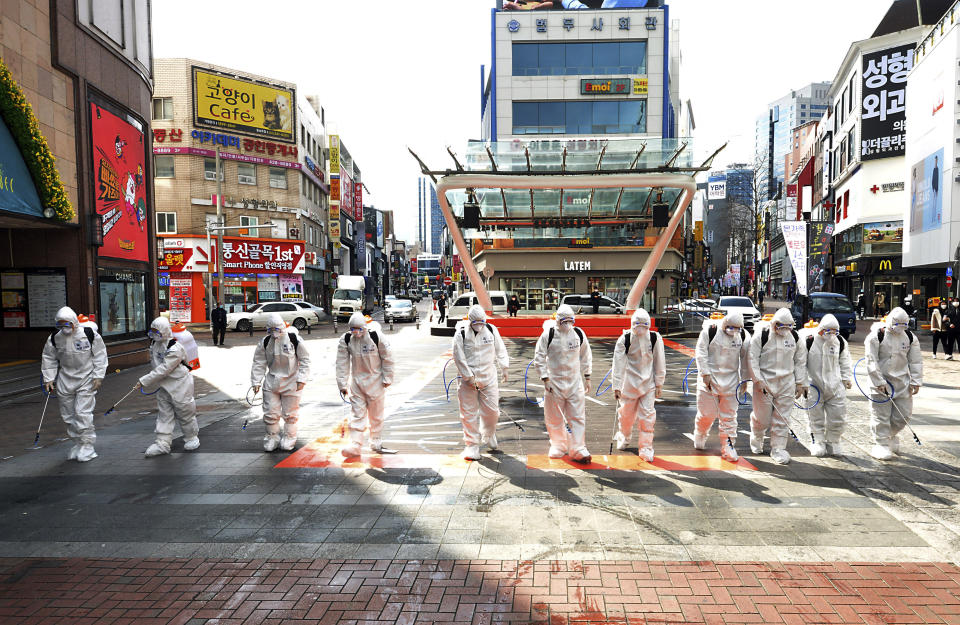 South Korean army soldiers wearing protective suits spray disinfectant to prevent the spread of the COVID-19 virus on a street in Daegu, South Korea, Thursday, Feb. 27, 2020. As the worst-hit areas of Asia continued to struggle with a viral epidemic, with hundreds more cases reported Thursday in South Korea and China, worries about infection and containment spread across the globe. (Lee Moo-ryul/Newsis via AP)