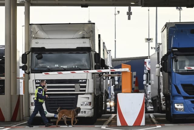 An employee of Eurotunnel and his dog check a truck on its way to Britain