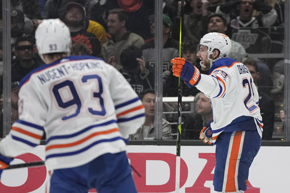 Edmonton Oilers center Leon Draisaitl, right, celebrates his goal as center Ryan Nugent-Hopkins skates behind during Game 3 of an NHL hockey Stanley Cup first-round playoff series against the Los Angeles Kings Friday, April 26, 2024, in Los Angeles. (AP Photo/Mark J. Terrill)