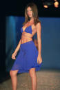 <p>Bei der Sao Paulo Fashion Week 2001 trug sie auf dem Catwalk einen blauen Rock und ein dazu passendes Bikinioberteil. (Quelle: Getty) </p>