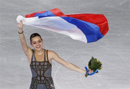 Russia's Adelina Sotnikova celebrates holding her flag at the end of the Figure Skating Women's free skating Program at the Sochi 2014 Winter Olympics, February 20, 2014. REUTERS/Issei Kato