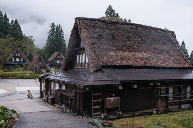 A boy on his bicycle in the village of Ainokura, Gokayama. The area is a UNESCO World Heritage Site due to its traditional thatched-roof farmhouses.