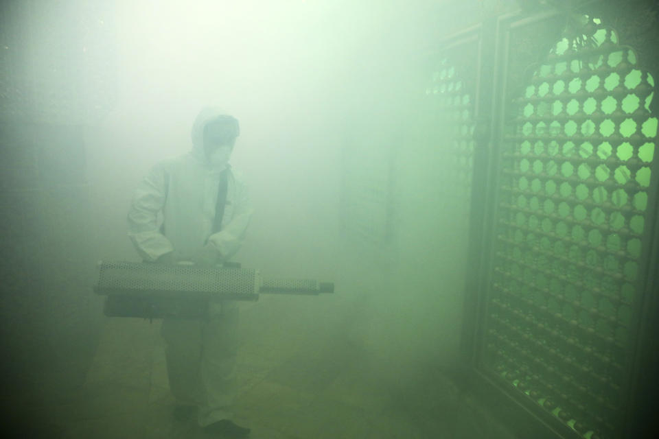 A firefighter disinfects the shrine of Saint Saleh to help prevent the spread of the new coronavirus in northern Tehran, Iran, Friday, March, 6, 2020.  A Health Ministry spokesman warned authorities could use unspecified “force” to halt travel between major cities.  (AP Photo/Ebrahim Noroozi)