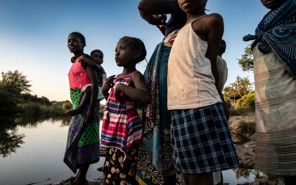Women and children on the banks of the Maramba River which contains the parasite leading to Schistosomiasis (Bilharzia) - Simon Townsley/The Telegraph