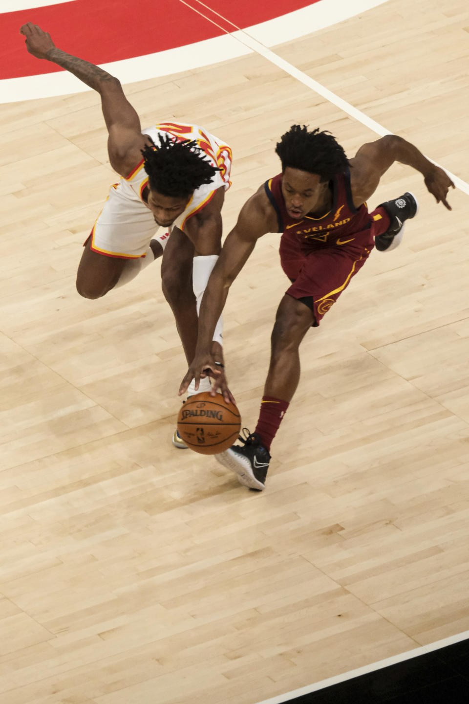 Atlanta Hawks forward Cam Reddish (22) and Cleveland Cavaliers guard Collin Sexton (2) dive for the ball during the first half of an NBA basketball game on Saturday, Jan. 2, 2021, in Atlanta. (AP Photo/Ben Gray)