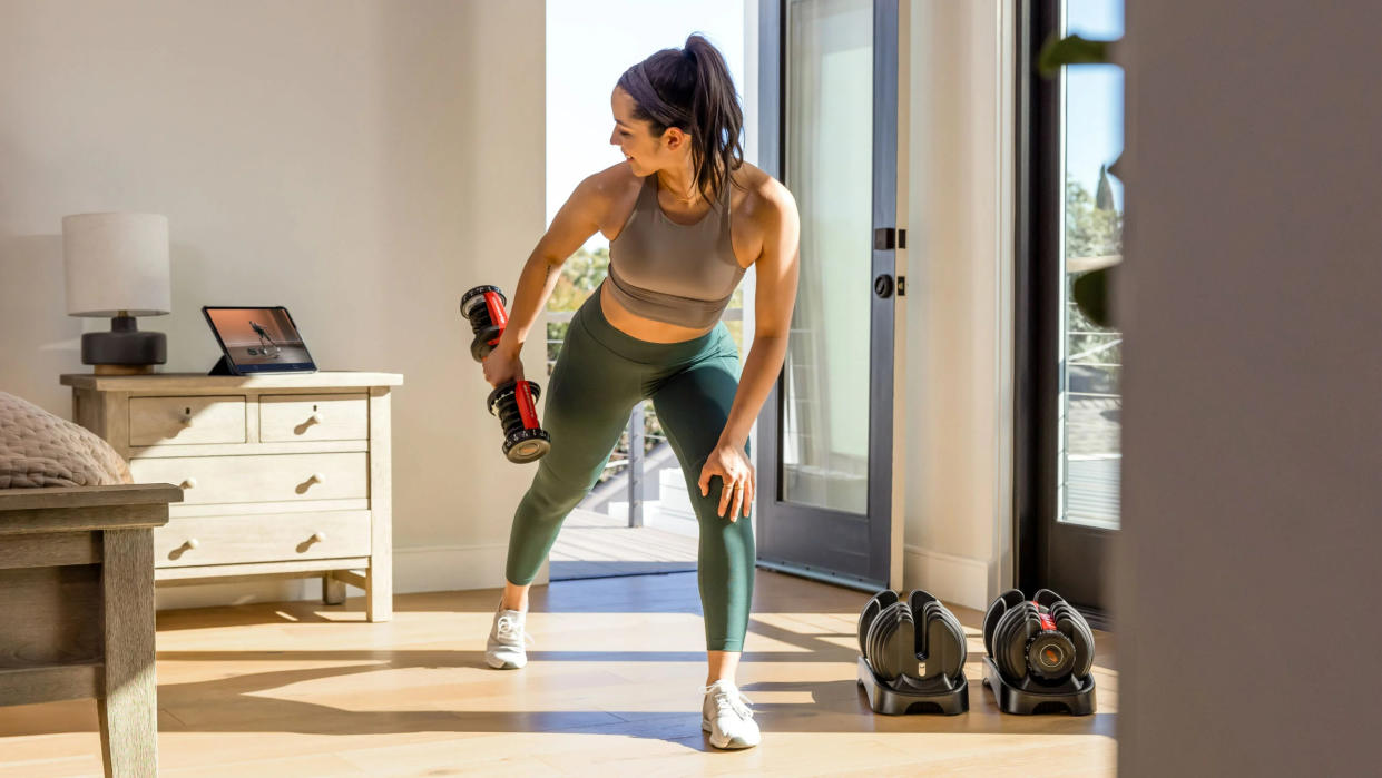  Woman working out with the BowFlex SelectTech 552 Dumbbells. 