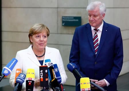 Christian Social Union (CSU) leader Horst Seehofer and Angela Merkel, leader of the Christian Democratic Union (CDU) talk to the media as they arrive at the German Parliamentary Society offices before the start of exploratory talks about forming a new coalition government in Berlin, Germany, October 20, 2017. REUTERS/Axel Schmidt