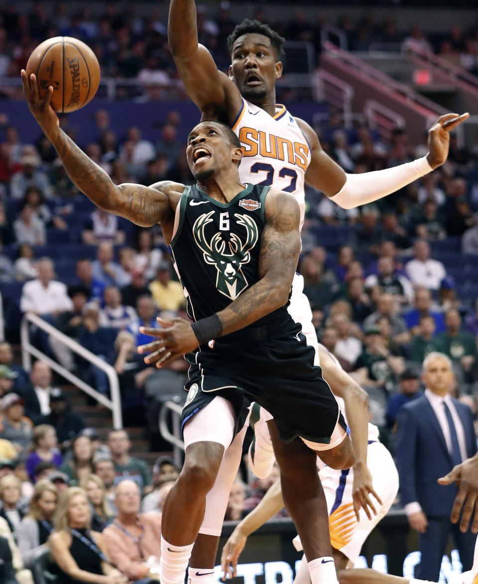 Milwaukee Bucks guard Eric Bledsoe (6) shoots past Phoenix Suns center Deandre Ayton (22) during the first half of an NBA basketball game, Monday, March 4, 2019, in Phoenix. (AP Photo/Matt York)