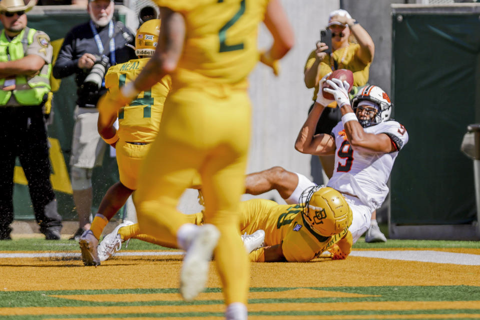 Oklahoma State wide receiver Bryson Green, right, catches a touchdown pass over Baylor cornerback AJ McCarty, on ground, during the first half of an NCAA college football game in Waco, Texas, Saturday, Oct. 1, 2022. (AP Photo/Gareth Patterson)